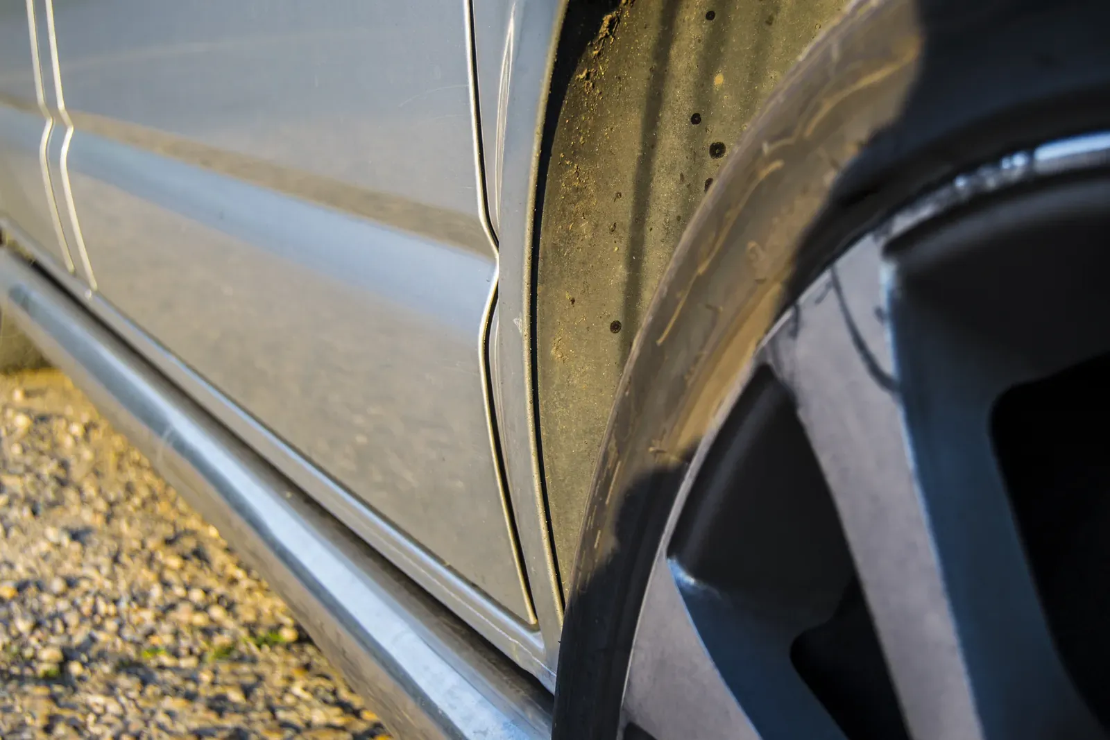 Curb-scuffed alloy wheel and lower panel on a silver car
