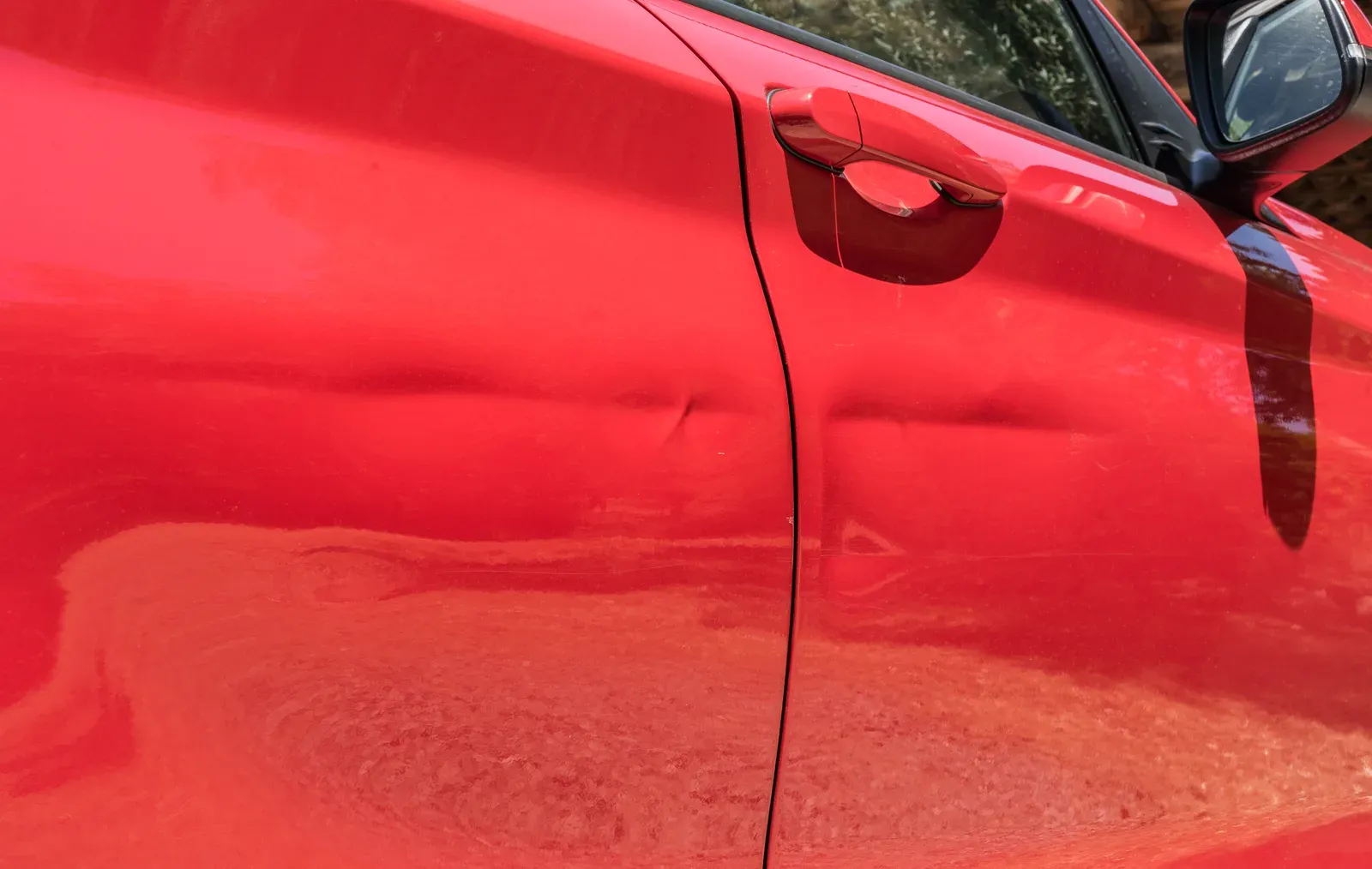 A dented door before repair