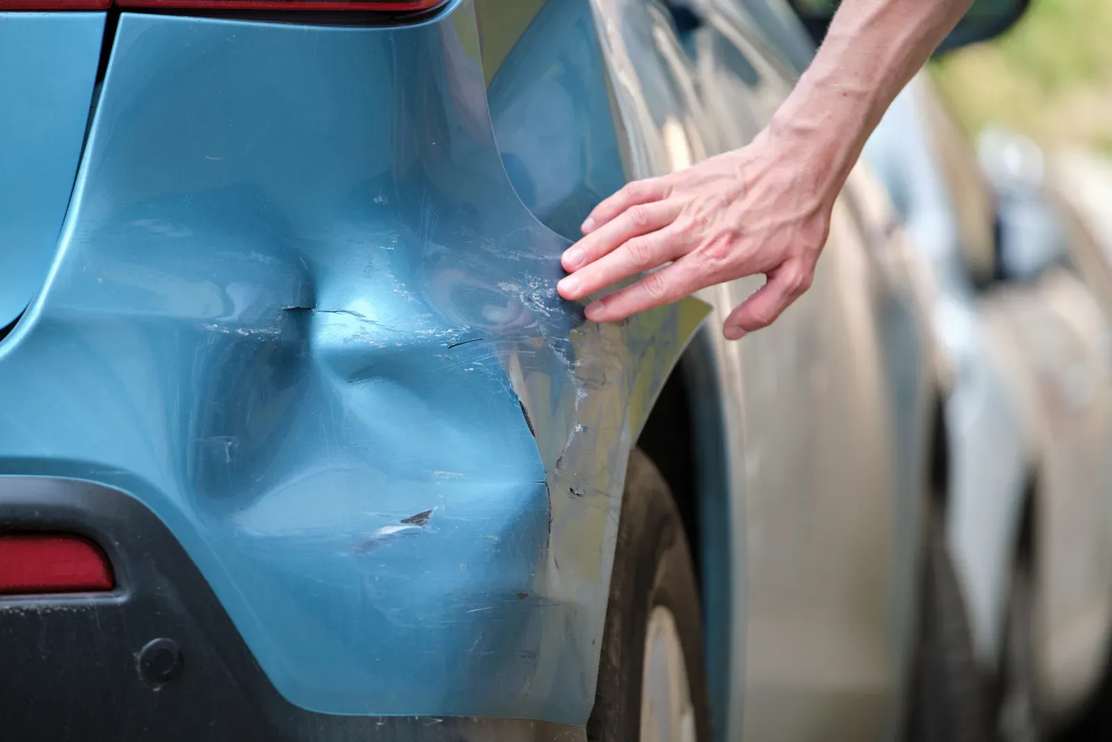 Fender damage on an older vehicle photographed before repair