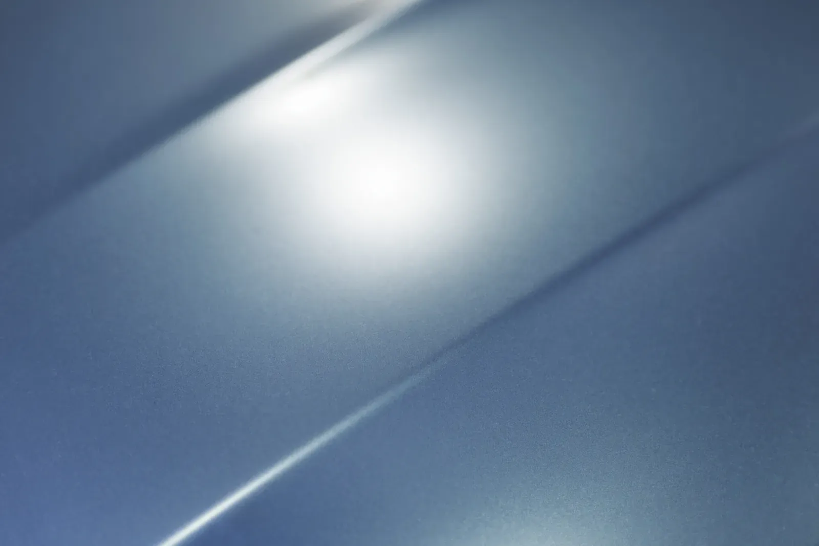 Macro view of glossy metallic automotive paint on a refinished body panel