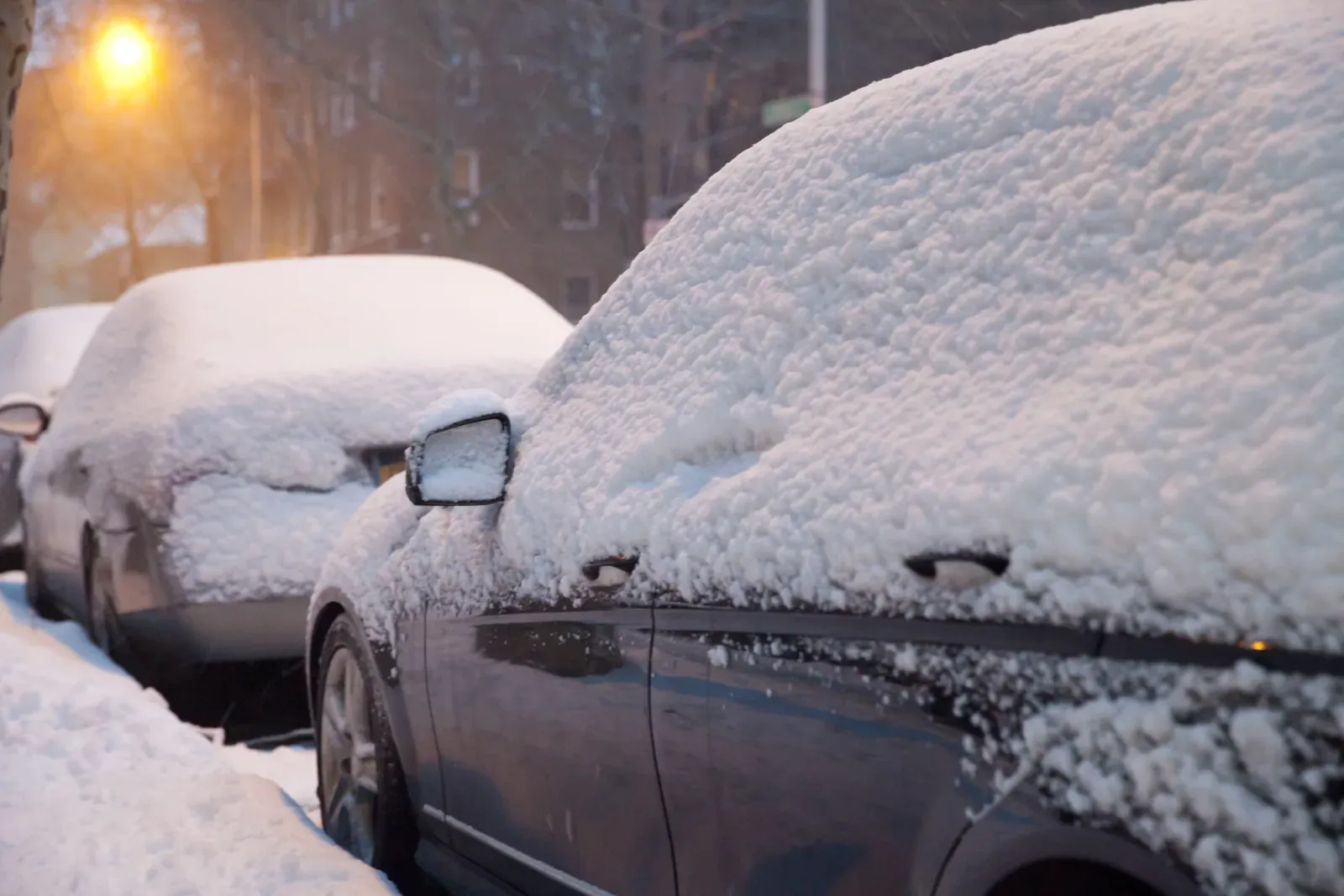 Snow-covered cars in a parking lot after a winter storm in the GTA