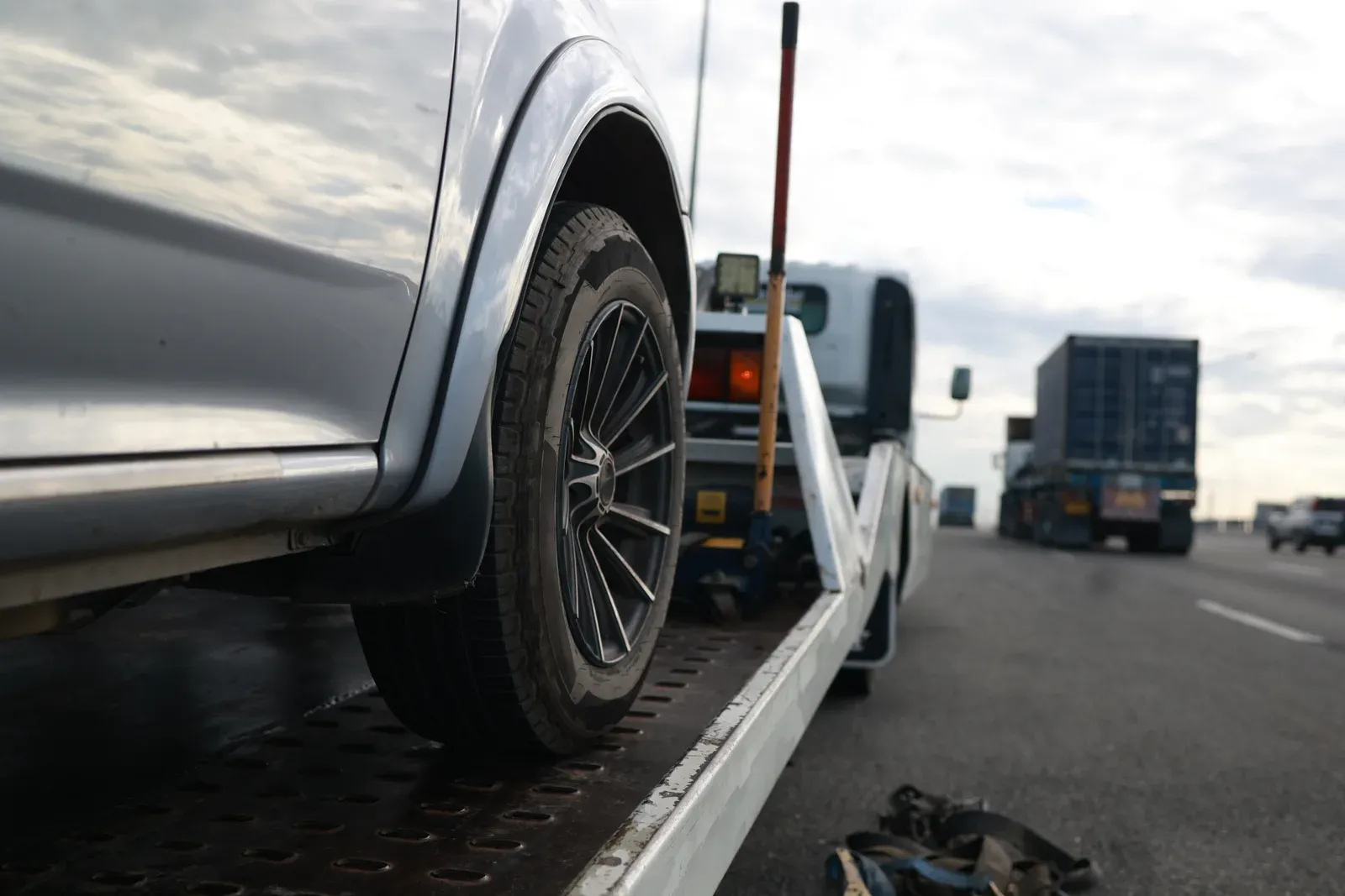 Damaged vehicle loaded onto a tow truck for delivery to Collision Auto Center in North York